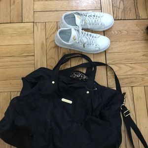 Black VS gym duffel and white nike sneakers gold
